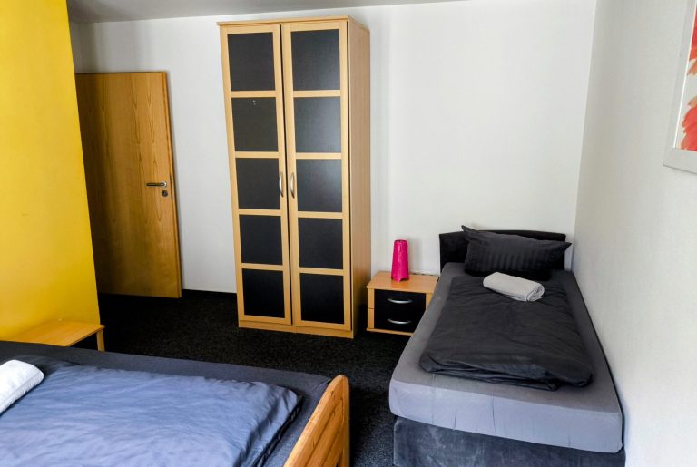 Schlafzimmer mit Doppel- und Einzelbett sowie Kleiderschrank – Ferienwohnung Rhein & Wein, Bacharach