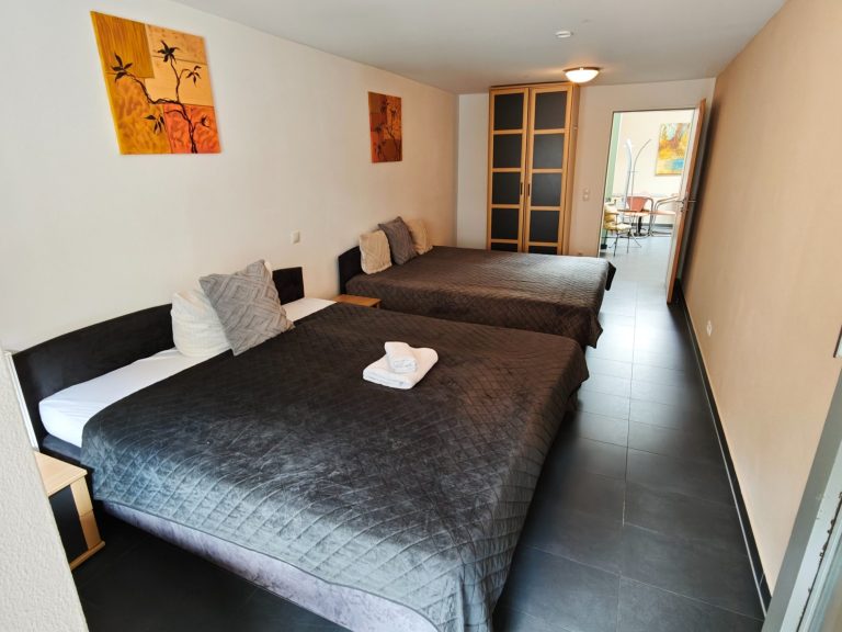 Ferienwohnung Altstadtquartier 16 – großes Schlafzimmer mit 2 Doppelbetten, Balkonblick auf Bacharach & Burg Stahleck, ideal für Gruppen