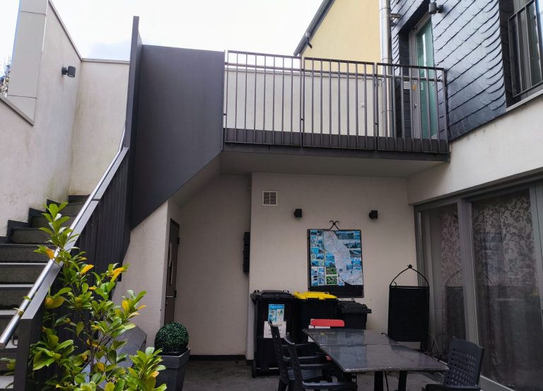 Innenhof mit Außentreppe und korrekt markierten Schlüsselboxen neben der Kellertür – Ferienwohnung Altstadtquartier 16 in Bacharach