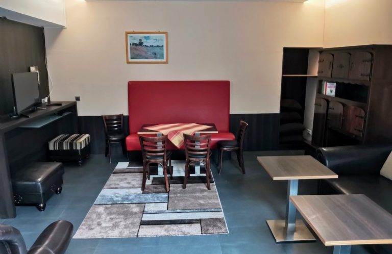 Offener Wohn- und Essbereich der Ferienwohnung mit Sitzecke, Esstisch und Küchenzeile – Bacchus Holiday Home