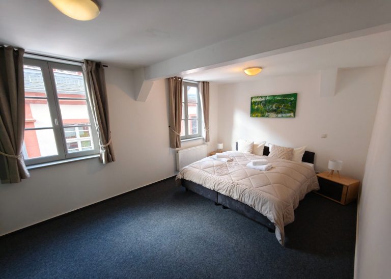 Ferienwohnung Altstadtquartier 16 – Schlafzimmer mit Doppelbett & Babybett, ideal für Familien mit Kleinkindern, Blick auf Burg Stahleck
