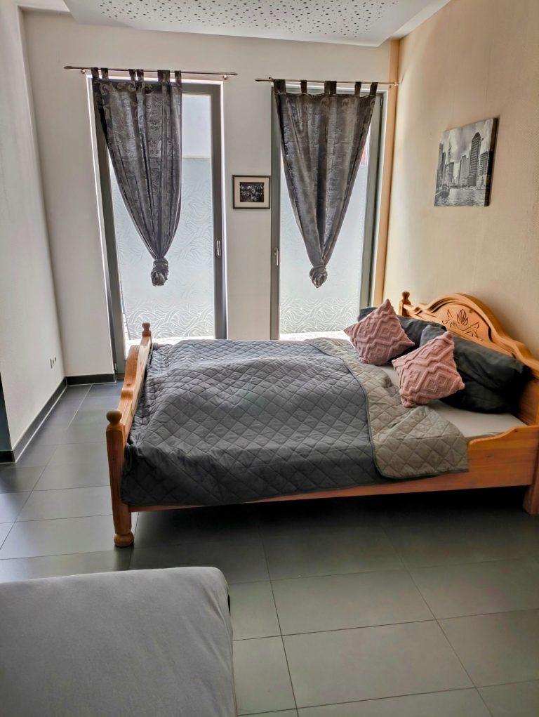 Offener Wohn- und Essbereich der Ferienwohnung mit Sitzecke, Esstisch und Küchenzeile – Bacchus Holiday Home